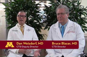 Video still showing Dan Weisdorf and Bruce Blazar,  with text indicating their names and titles.